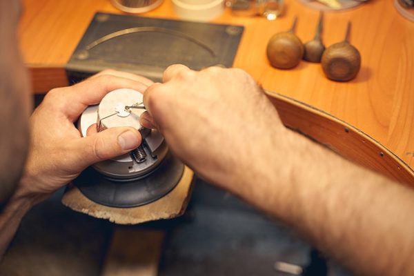 Craftsperson using a steel graver in his work Cropped photo of a professional male jeweler cutting out a design on a piece of metal