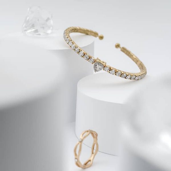 Golden with diamonds bracelet between diamonds on white